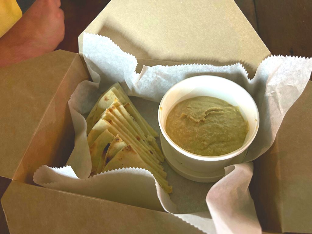 Hummus and pita bread in a cardboard box