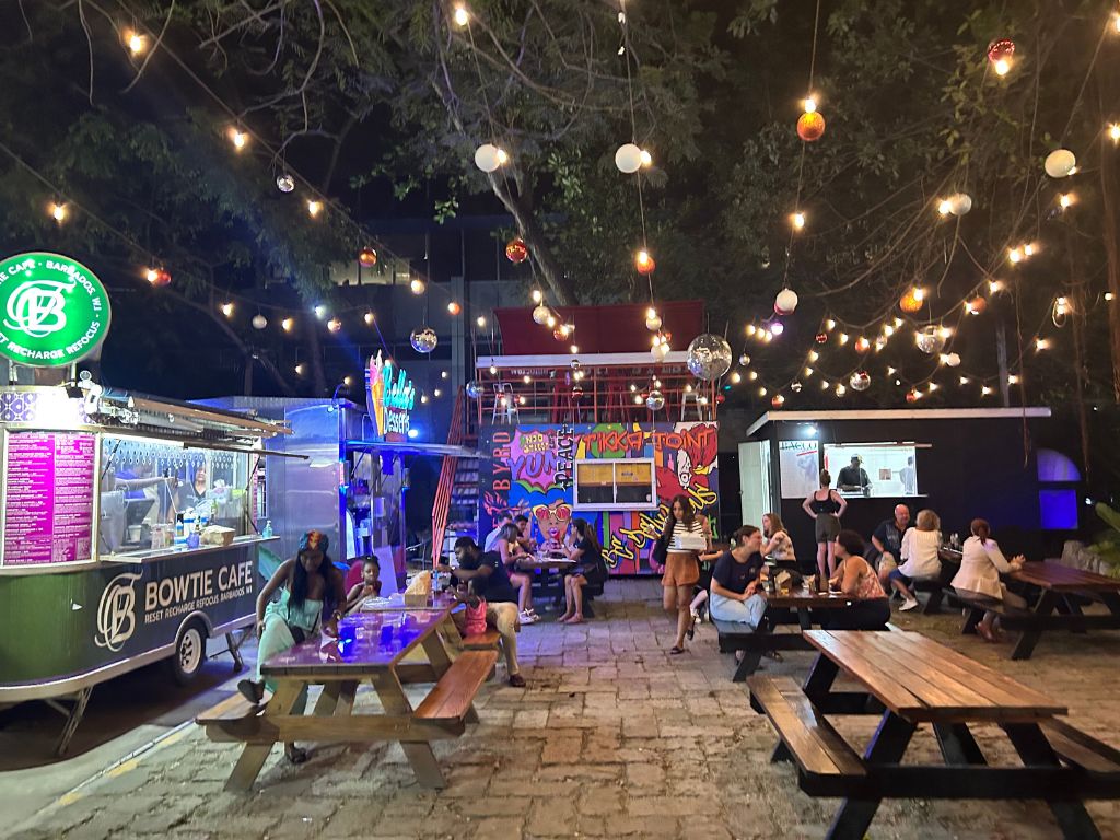 Picnic tables under twinkle lights at Worthing Square Barbados
